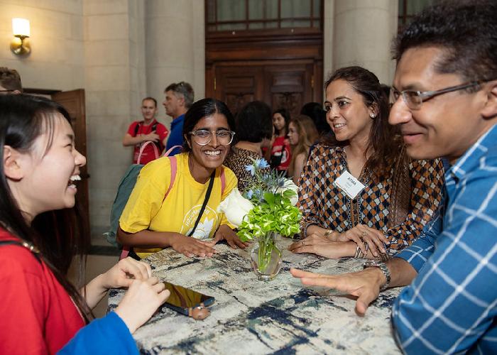 Students sitting at table laughing and talking